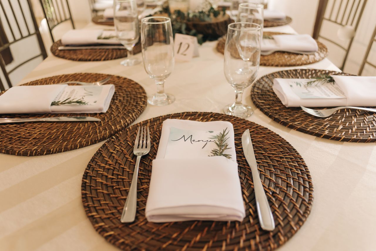 Chic table setting featuring wicker placemats and elegant glassware.